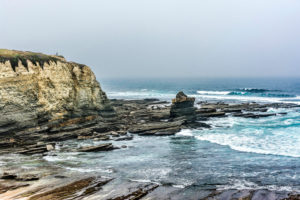 Europe, Portugal, Centro Region, Peniche, Prainha do Abalo, bay with cliffs, lonely man taking a selfie Europe, Portugal, Centro Region, Peniche, Prainha do Abalo, bay with cliffs, lonely man taking a selfie